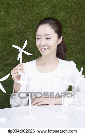 Stock Photograph - woman playing with pinwheels on the table. Fotosearch