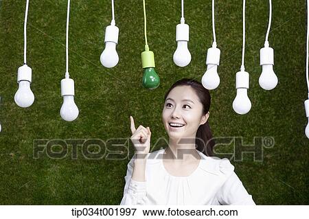 woman pointing out one the bulbs hanging on the ceiling View Large Photo Image Stock Photo - woman pointing out one the bulbs hanging on the ceiling. Fotosearch
