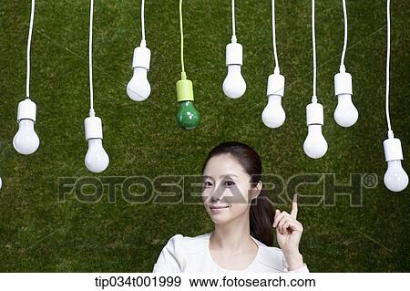 woman pointing out one the bulbs hanging on the ceiling View Large Photo Image Stock Photo - woman pointing out one the bulbs hanging on the ceiling. Fotosearch