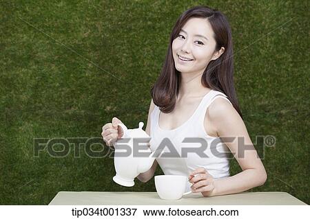 Stock Photo - woman pouring tea. Fotosearch