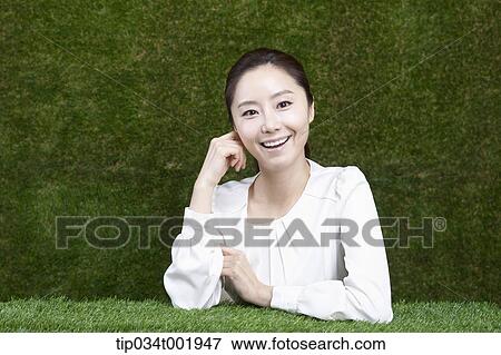 woman sitting and smiling with her chin propped on her hands View Large Photo Image Stock Photo - woman sitting and smiling with her chin propped on her hands. Fotosearch