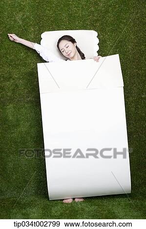 Stock Photo - woman stretching herself in the paper bedding. Fotosearch