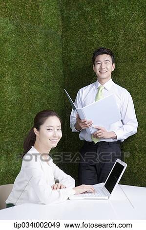 woman using computer and man holding a folder View Large Photo Image Stock Photo - woman using computer and man holding a folder. Fotosearch