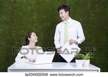 woman using computer and man holding a folder View Large Photo Image Stock Photo - woman using computer and man holding a folder. Fotosearch