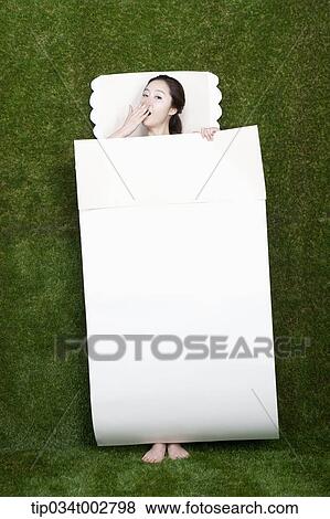 Stock Photo - woman yawning in the paper bedding. Fotosearch