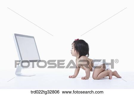 Stock Photograph - A baby crawling to the monitor. Fotosearch