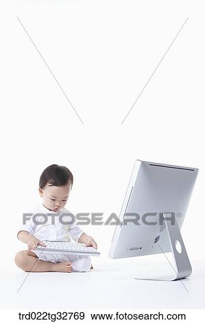 Stock Photo - A baby holding the keyboard. Fotosearch
