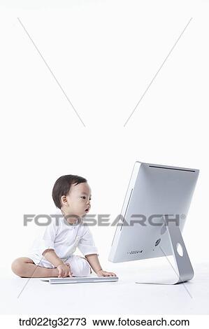 Stock Image - A baby looking at the monitor. Fotosearch