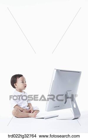 A baby sitting with a computer View Large Photo Image Picture - A baby sitting with a computer. Fotosearch