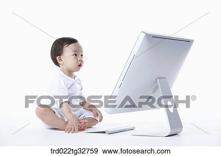 Stock Photo - A baby sitting with a computer. Fotosearch