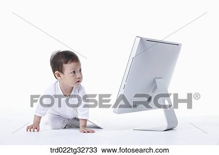 Stock Image - A baby sitting with a monitor. Fotosearch