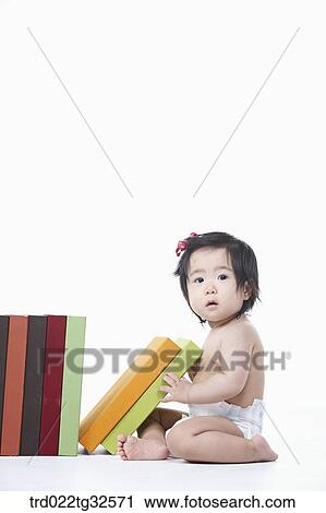 Stock Image - A baby sitting with the books. Fotosearch