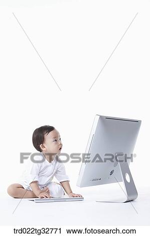 Stock Image - A baby touching on the keyboard. Fotosearch