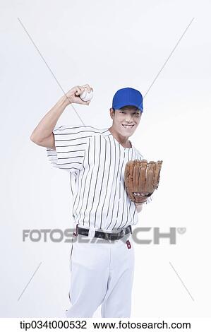 Stock Image - A baseball player holding up a ball. Fotosearch