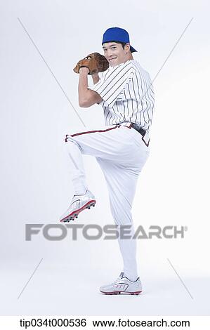 Stock Photograph - A baseball player pitching a ball. Fotosearch