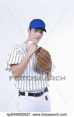Stock Photo - A baseball player with a ball and glove. Fotosearch