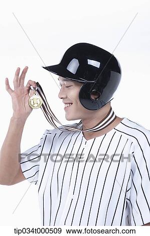 Stock Photo - A baseball player with gold medal. Fotosearch