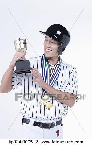 Stock Image - A baseball player with gold medals and trophy. Fotosearch