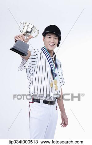 Stock Image - A baseball player with gold medals and trophy. Fotosearch