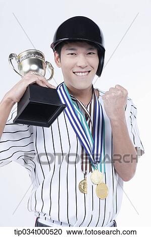 Stock Image - A baseball player with gold medals and trophy. Fotosearch