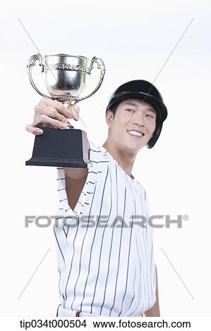 Picture - A baseball player with gold trophy. Fotosearch