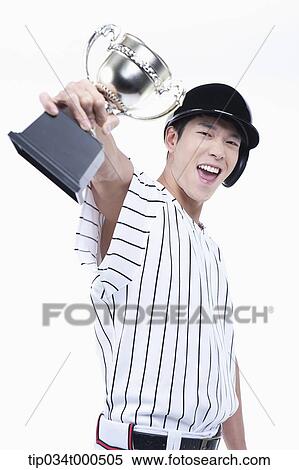 Stock Photography - A baseball player with gold trophy. Fotosearch