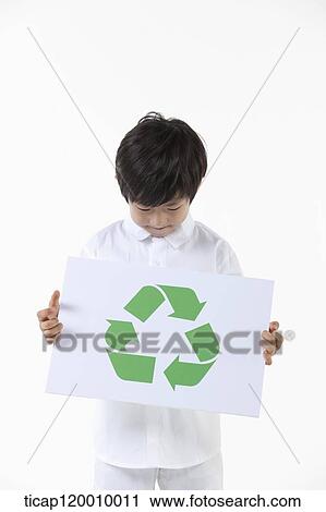 Stock Image - A boy looking down on recycling symbol . Fotosearch