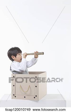 A boy looking through the telescope in the box View Large Photo Image Stock Photo - A boy looking through the telescope in the box. Fotosearch