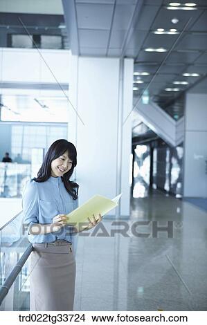 Picture - A business woman looking over the document. Fotosearch