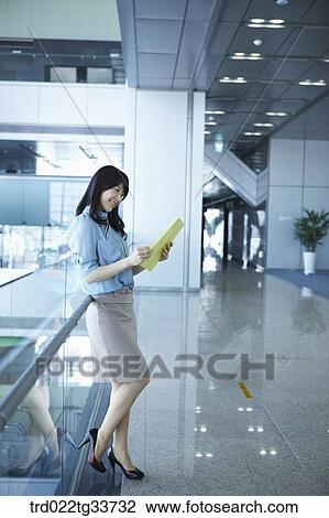 Stock Image - A business woman looking over the document. Fotosearch