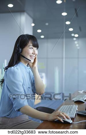 A business woman putting on the headset View Large Photo Image Stock Image - A business woman putting on the headset. Fotosearch
