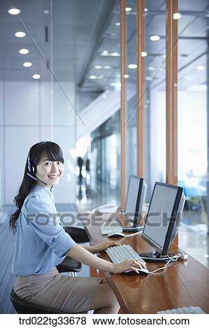 A business woman putting on the headset View Large Photo Image Stock Photo - A business woman putting on the headset. Fotosearch