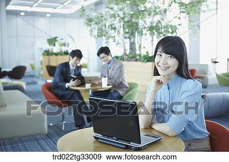Stock Photo - A business woman smiling with the laptop . Fotosearch