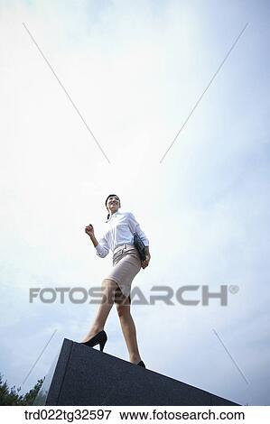 Stock Photo - A business woman standing with the briefcase. Fotosearch