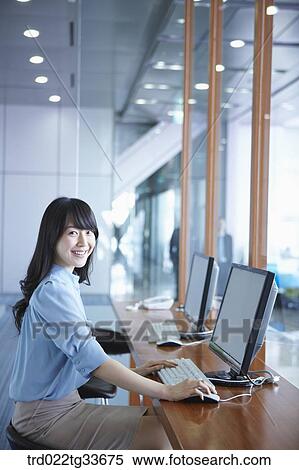 Stock Photography - A business woman using computer in the lounge. Fotosearch