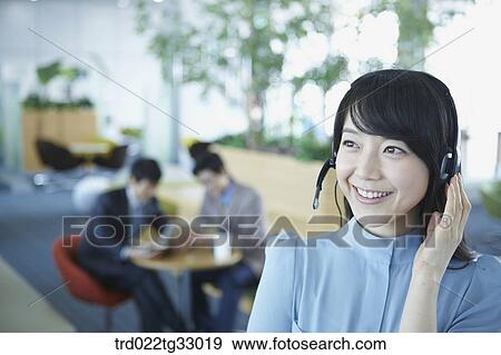 Stock Photo - A business woman with a headphone on her head. Fotosearch