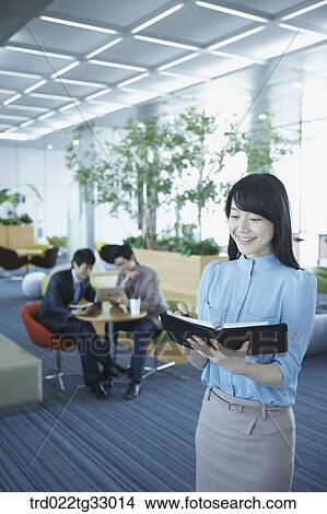 Picture - A business woman writing the schedule on the planner. Fotosearch