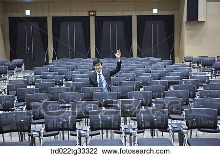 Stock Image - A businessman asking the question in the auditorium. Fotosearch