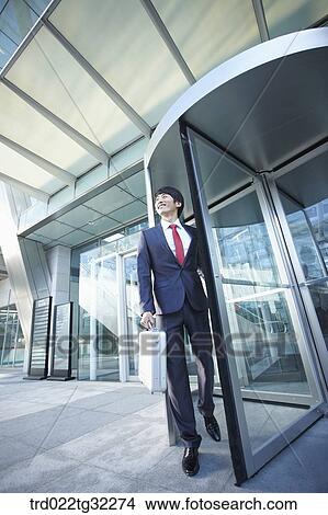 A businessman getting out through the revolving door View Large Photo Image Picture - A businessman getting out through the revolving door . Fotosearch
