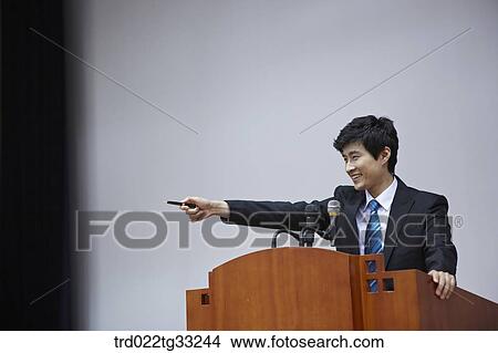 Picture - A businessman having presentation on the stage. Fotosearch