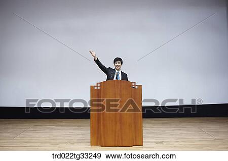 Stock Photo - A businessman having presentation on the stage. Fotosearch
