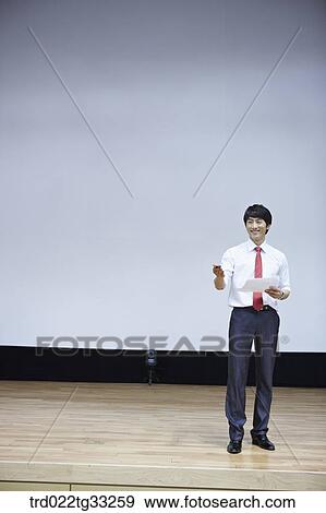 A businessman having presentation on the stage View Large Photo Image Stock Photo - A businessman having presentation on the stage. Fotosearch