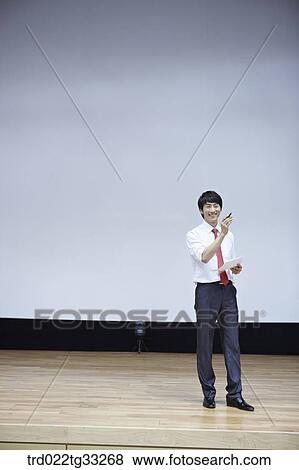 A businessman having presentation on the stage View Large Photo Image Stock Photo - A businessman having presentation on the stage. Fotosearch