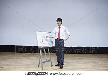 Picture - A businessman having presentation with a white board. Fotosearch