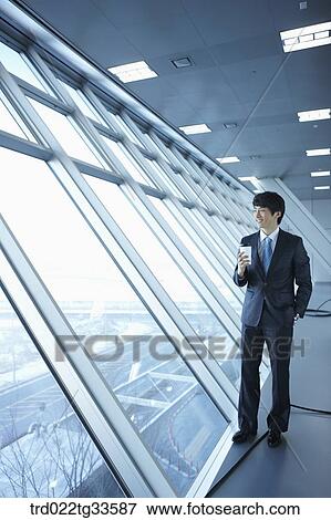 A businessman having the coffee by the window View Large Photo Image Stock Photo - A businessman having the coffee by the window. Fotosearch