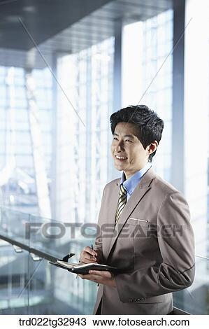 A businessman holding a pen and planner View Large Photo Image Stock Image - A businessman holding a pen and planner. Fotosearch