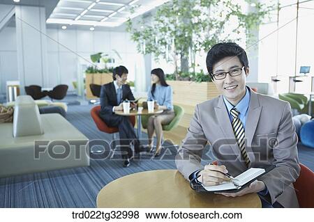 A businessman holding a planner in the lounge View Large Photo Image Stock Photo - A businessman holding a planner in the lounge. Fotosearch