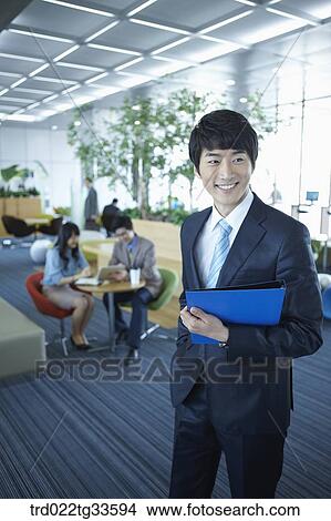 Picture - A businessman holding the document in the lounge. Fotosearch