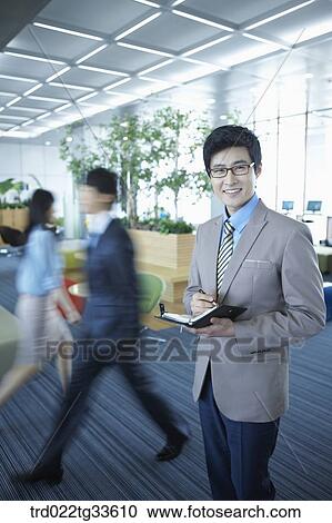 A businessman holding the planner View Large Photo Image Stock Image - A businessman holding the planner. Fotosearch