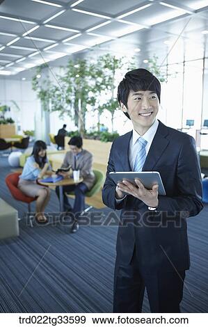 A businessman holding the tablet PC View Large Photo Image Stock Photo - A businessman holding the tablet PC. Fotosearch